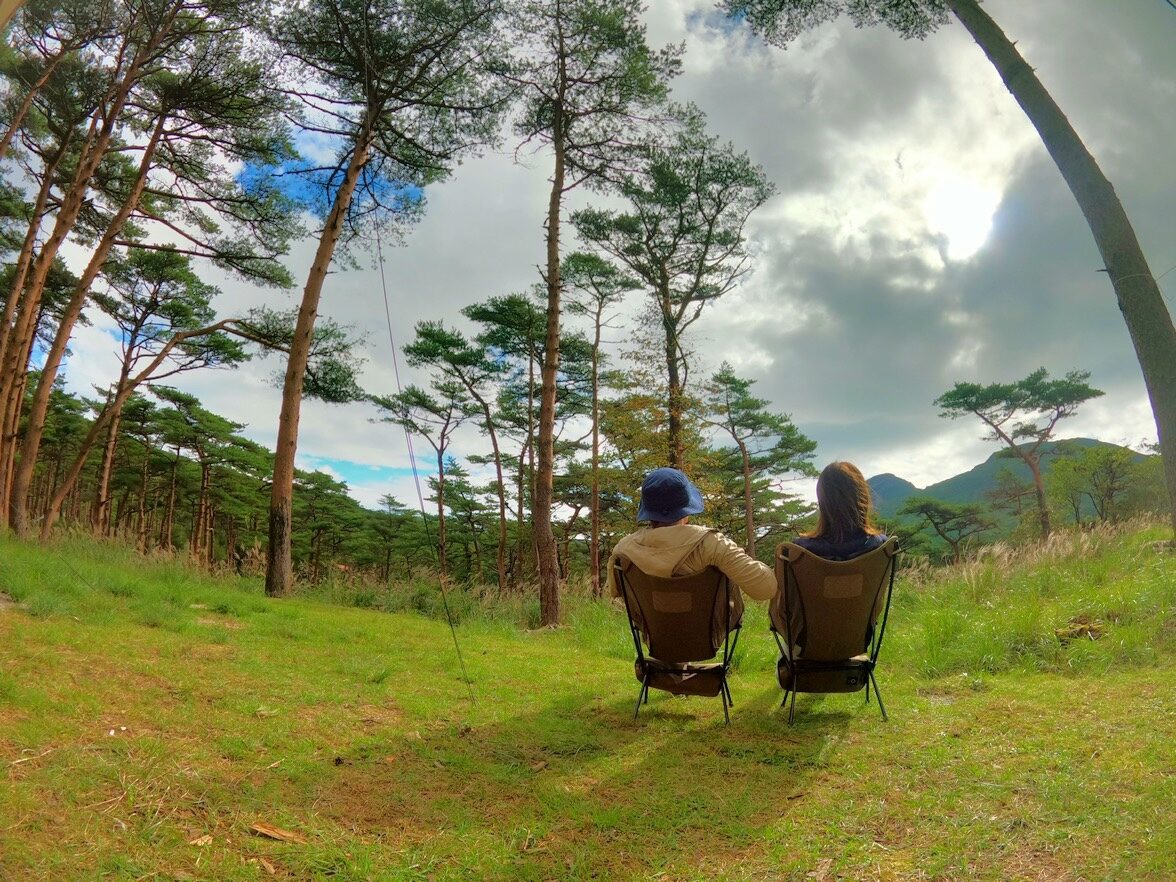 えびの高原キャンプ村で椅子に座る男女